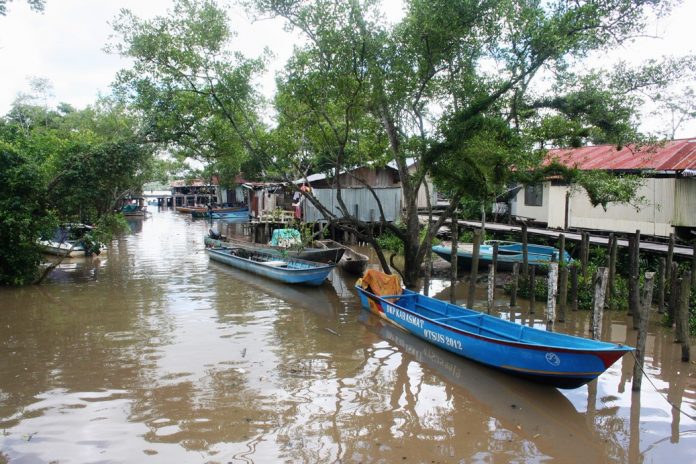 jalanan di agars tergenang oleh serbuan air laut ketika pasang