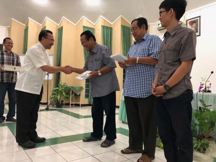 Uskup Agung KAS Mgr. Robertus Rubiyatmoko (kiri) secara simbolis menyerahkan buku baru mengenang almarhum Mgr. Johannes Pujasumarta Pr kepada para imam saat pertemuan UNIO KAS di Rumah Retret Griya Paseban, Bongsari, Semarang, Senin (17/7/18)