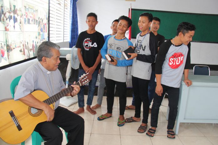 Uskup Agung Mgr. Agustinus Agus main gitar dalam acara perayaan Natal di Lapas Anak Pontianak. (Samuel Bjp/Komsos KAP)