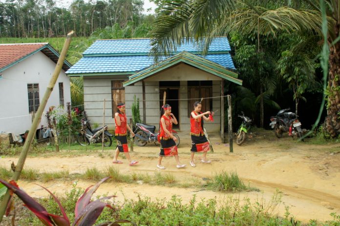 Ilustrasi - Tiga gadis remaja Dayak di Stasi Tanjung Beringin berjalan menuju kapel stasi mengikuti misa bersama Mgr. Pius Riana Prapdi (Mathias Hariyadi)