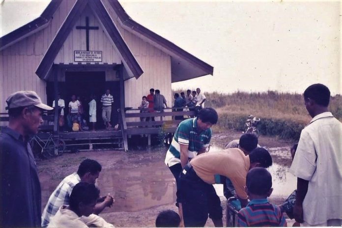 Pastor mesti mencuci kaki sebelum masuk Gereja Transmigrasi Stasi Sebakung, Paroki Penajam, Keuskupan Agung Samarinda, Kaltim. (Dok. Liem Tjay)