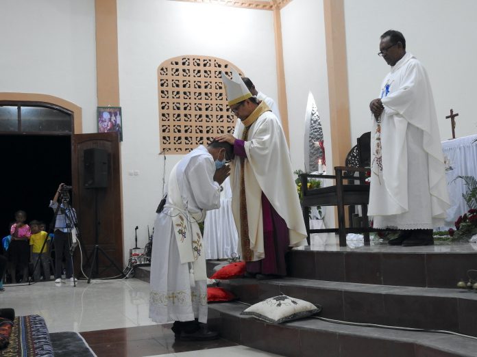 Penumpangan tangan oleh Uskup Penahbis Mgr. Paulinus Yan Olla MSF di atas kepala Diakon Markus Ngatun Suparno Pr menandai inti prosesi penerimaan Sakramen Imamat dan sah pula tahbisan imamat. (Angel Li)
