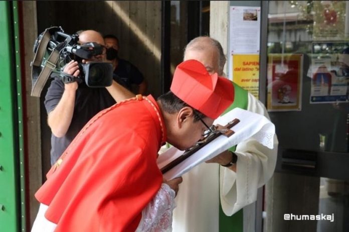 Uskup KAJ Ignatius Suharyo mencium salib sebelum memimpin Perayaan Ekaristi sebagai bagian dari seremoni possesio canonica di mana diberikan gelar kehormatan di sebuah gereja di Roma. (KAJ)