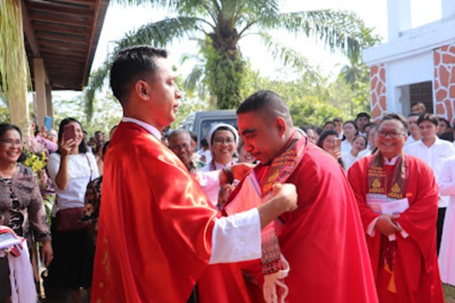 Pastor Paroki St. Paulus Pinang Raya di Kabupaten Bengkulu Utara kalungkan selempang kepada rekan imam saat peresmian paroki baru. (Juliana Sriana Sinaga)