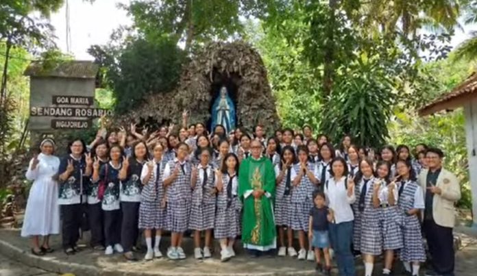 Setelah pelayanan koor misa di Gua Maria Sendang Rosario Ngijorejo, para murid SMA St. Dominikus Wonosari berpose bersama imam dan pembina. (Dorothea Pane Melia)