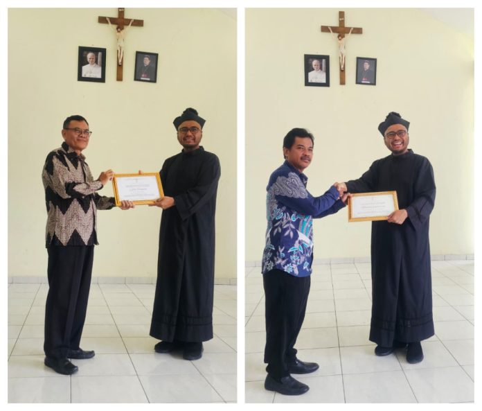 Pastor Paroki Purwakarta Romo Istimoer Bayu Ajie Pr menyerahkan sertifikat tanda terimakasih atas pelayanan para penggiat Gereja Salib Suci Paroki Purwakarta. (Panitia)